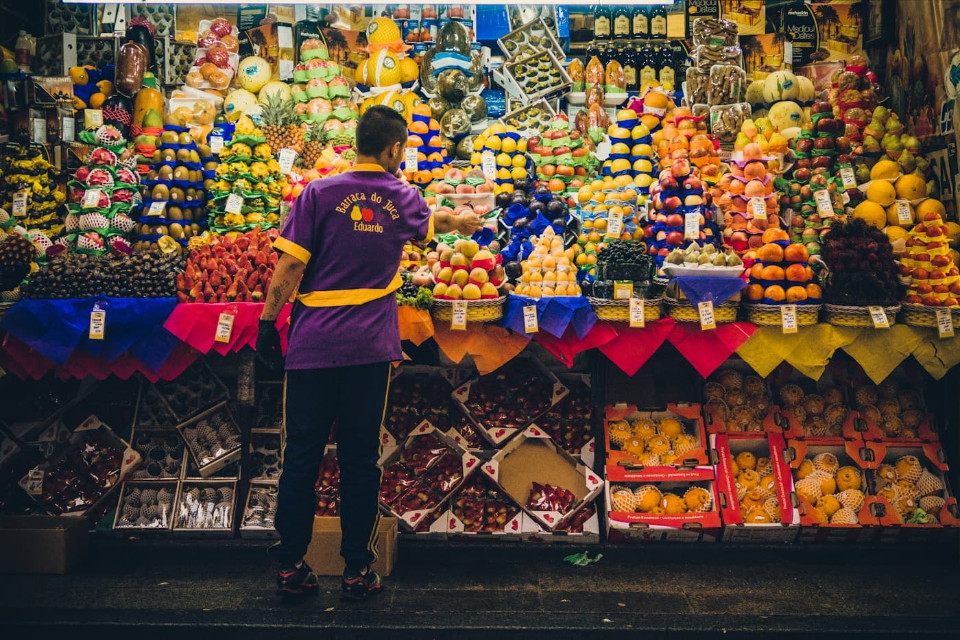 Feira brasileira com bancas coloridas de frutas e produtos